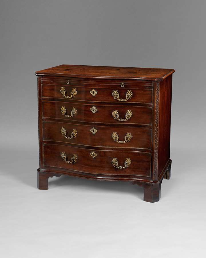 A George III period mahogany serpentine commode